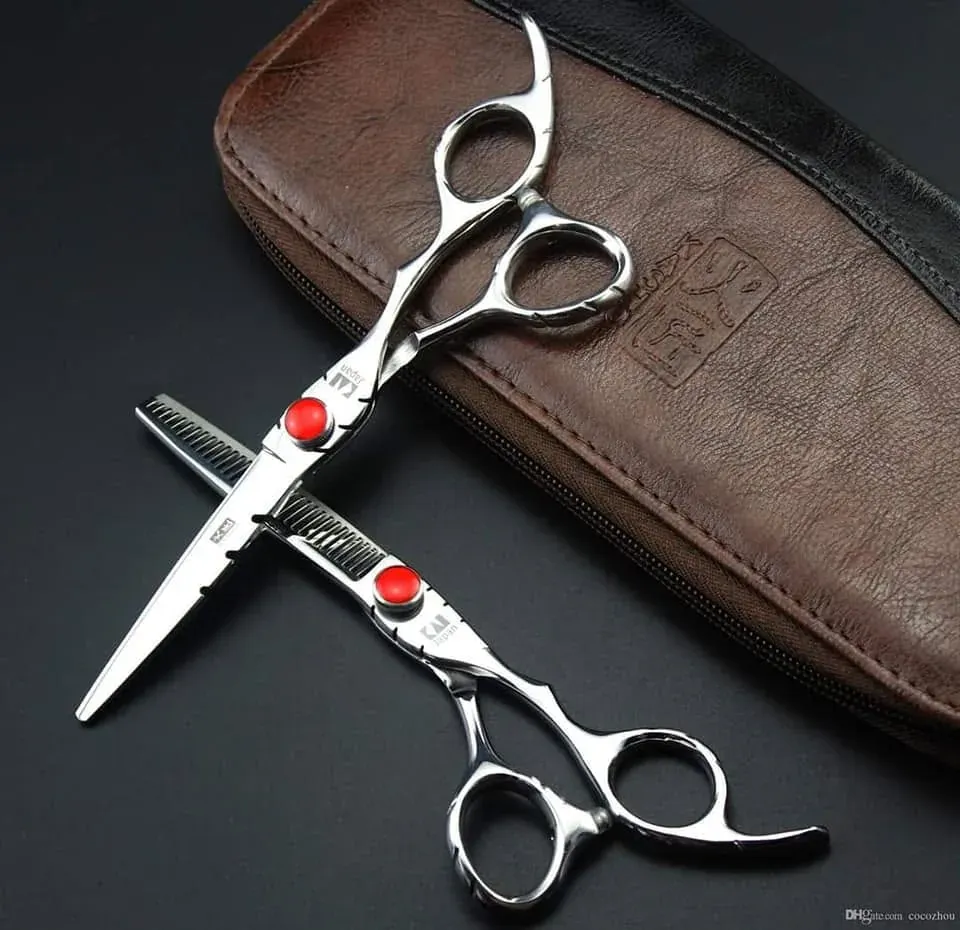 Ciseaux de coiffure professionnels posés sur un étui de cuir.